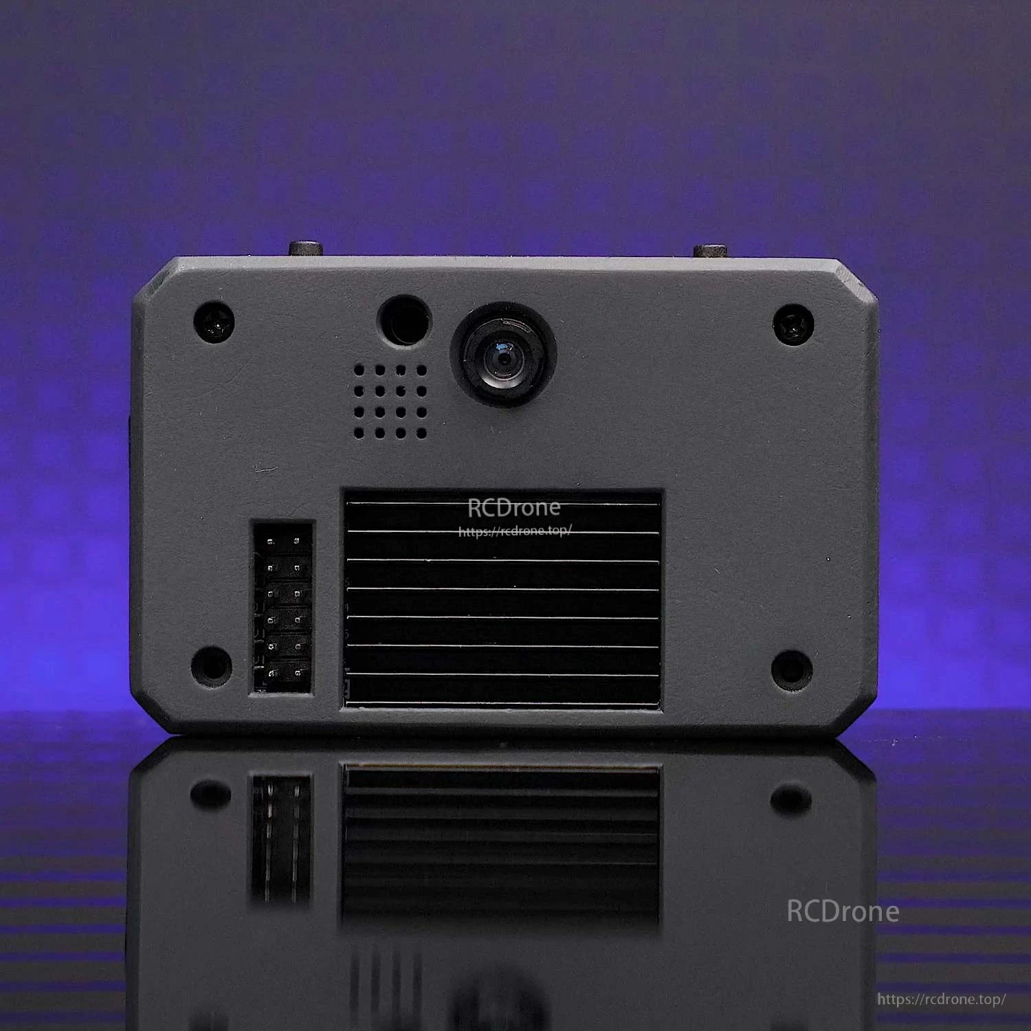 Rear view of the module showing camera lens, speaker holes, vent grille, and pin header connector