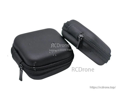 Angled view of two compact black zip cases with zipper track and pull tab visible for small electronics