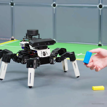 Hexapod robot demo with hand holding blue block in front of onboard depth camera
