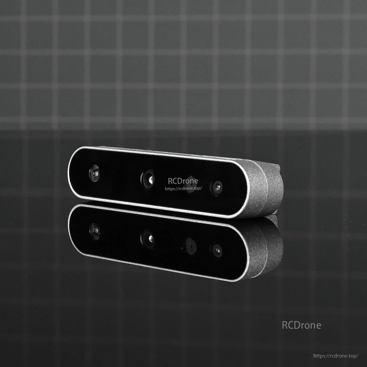 Low-light product photo on dark grid background showing front face and lens layout