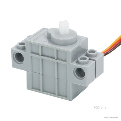 Gray building block servo motor close-up, side profile with output shaft and attached cable