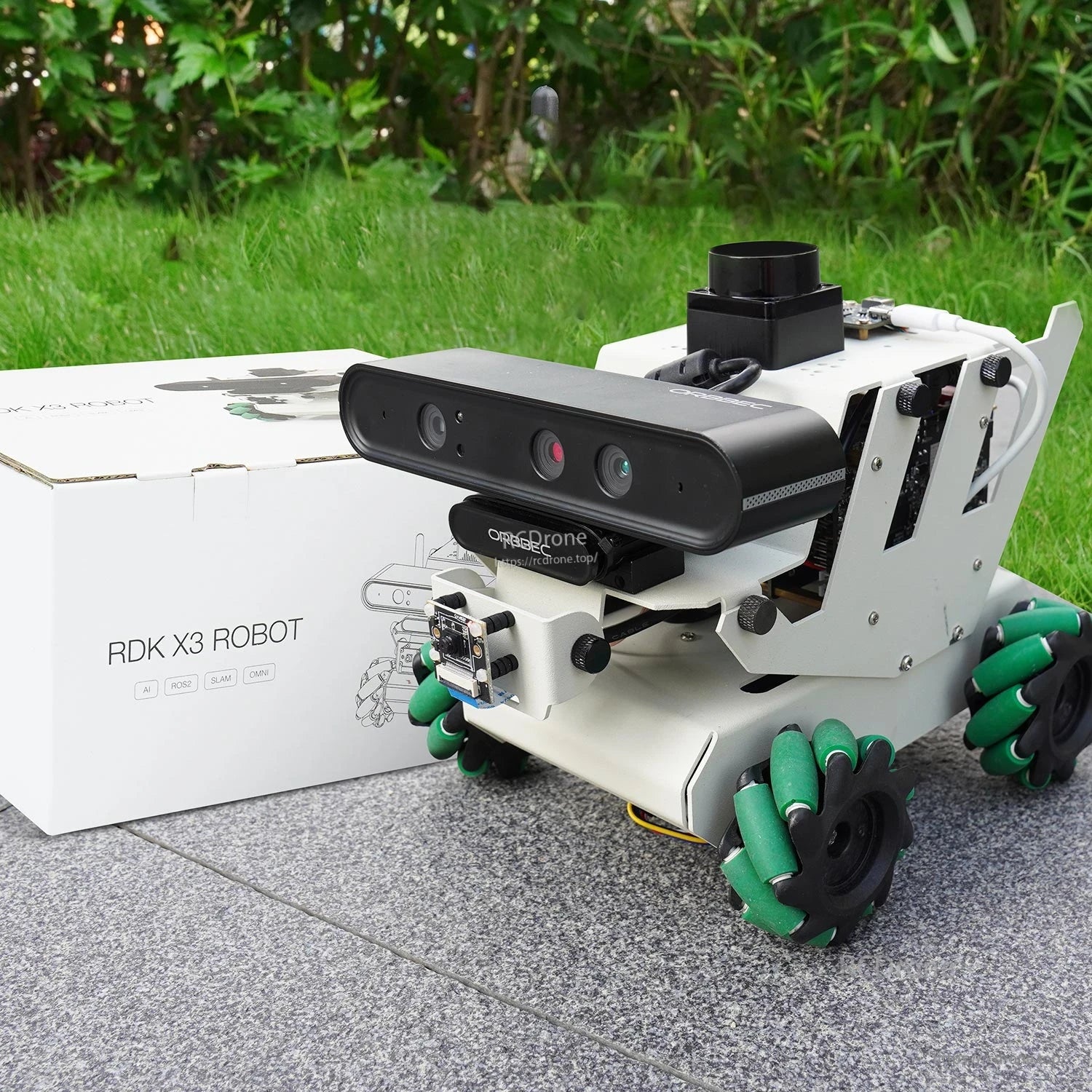 Yahboom RDK ROS2 Robot shown outdoors beside RDK X3 ROBOT retail box packaging