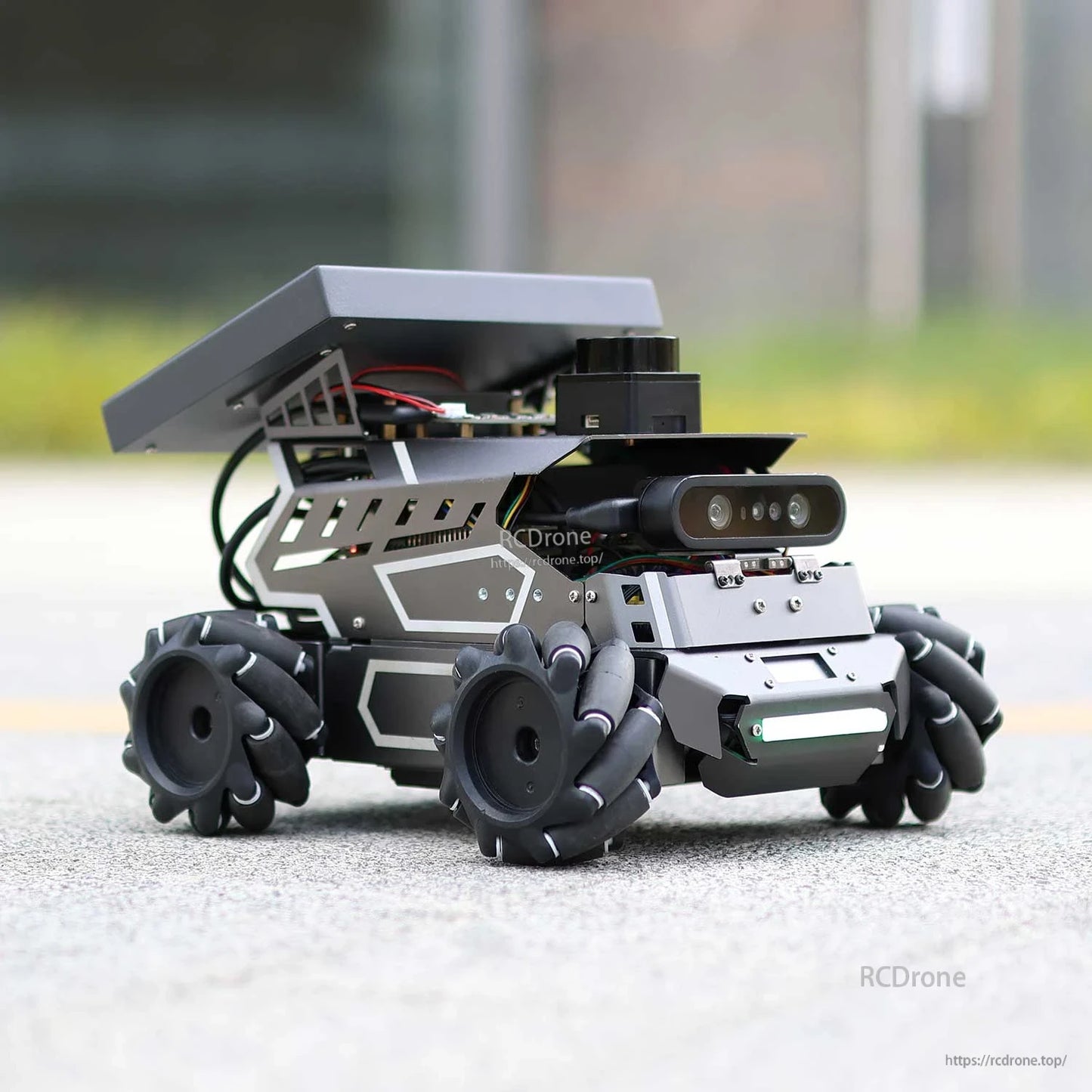 Side-front view of robot on pavement showing angled top plate, wheel set, and front sensor modules