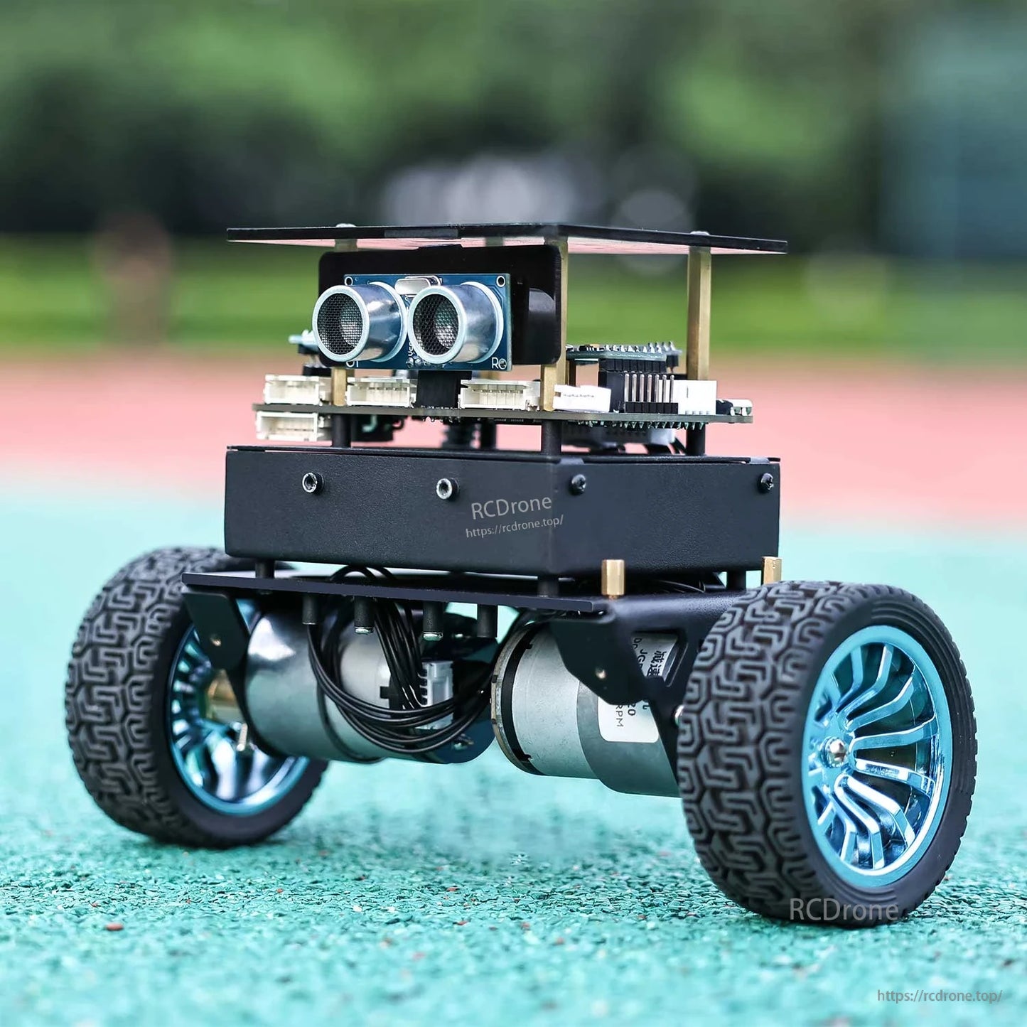 Rear three-quarter view of self-balancing robot car on outdoor track surface