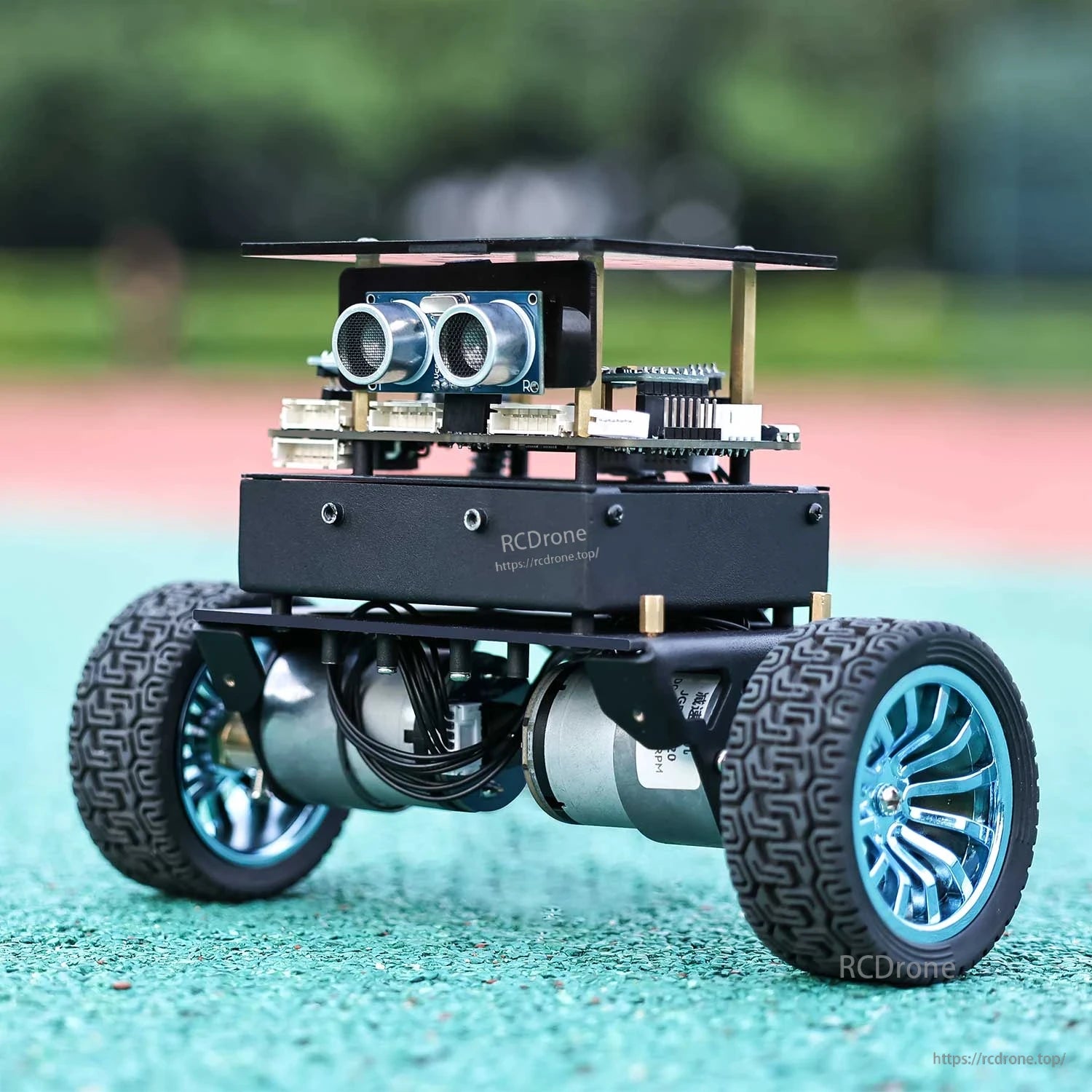 Rear three-quarter view of self-balancing robot car on outdoor track surface