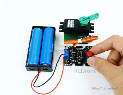Demo setup with battery pack and standard servo connected; hand adjusting knob on controller board