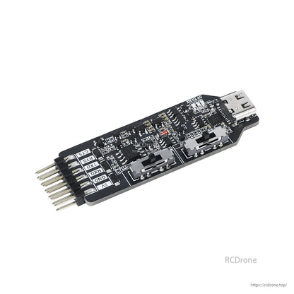 Angled top view of the serial port converter board showing switches, USB-C connector, and pin header