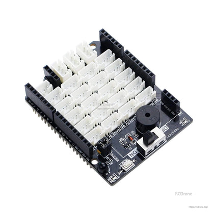 Close-up of expansion board with dense PH2.0 port grid, onboard buzzer and slide switch near corner