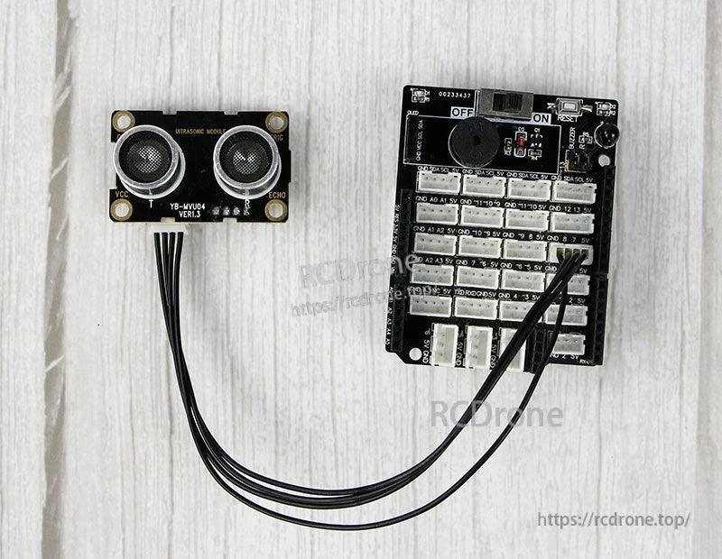 Ultrasonic sensor module connected by cable to controller/IO board on tabletop, wiring example setup