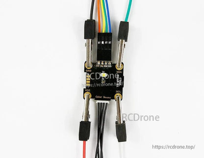 Close-up of module wiring using alligator clips and DuPont jumper on labeled GND/SDA/SCL/VCC pins