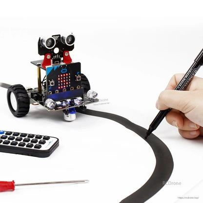Bitbot robot car line-tracking demo on curved black tape track with IR remote and screwdriver nearby