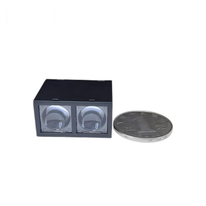 Yunshis MVR2TB ToF laser ranging sensor next to a coin for size reference, dual lens front shown