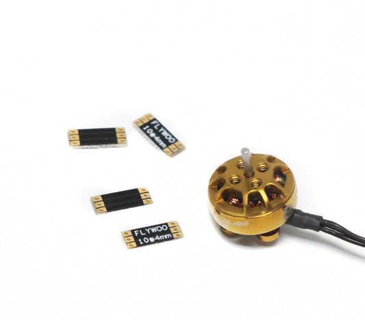 Set of four FLYWOO 10×4mm frame arm boards with gold solder pads, pictured beside a small brushless motor