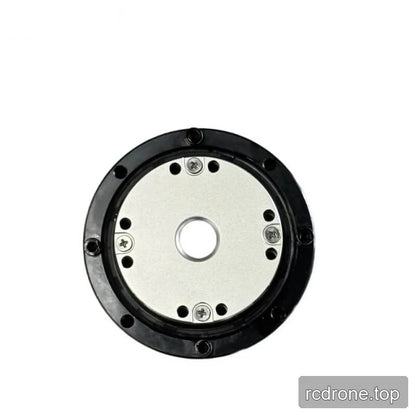 Close front view of the motor showing the circular metal plate, center opening, screws, and surrounding mounting holes.