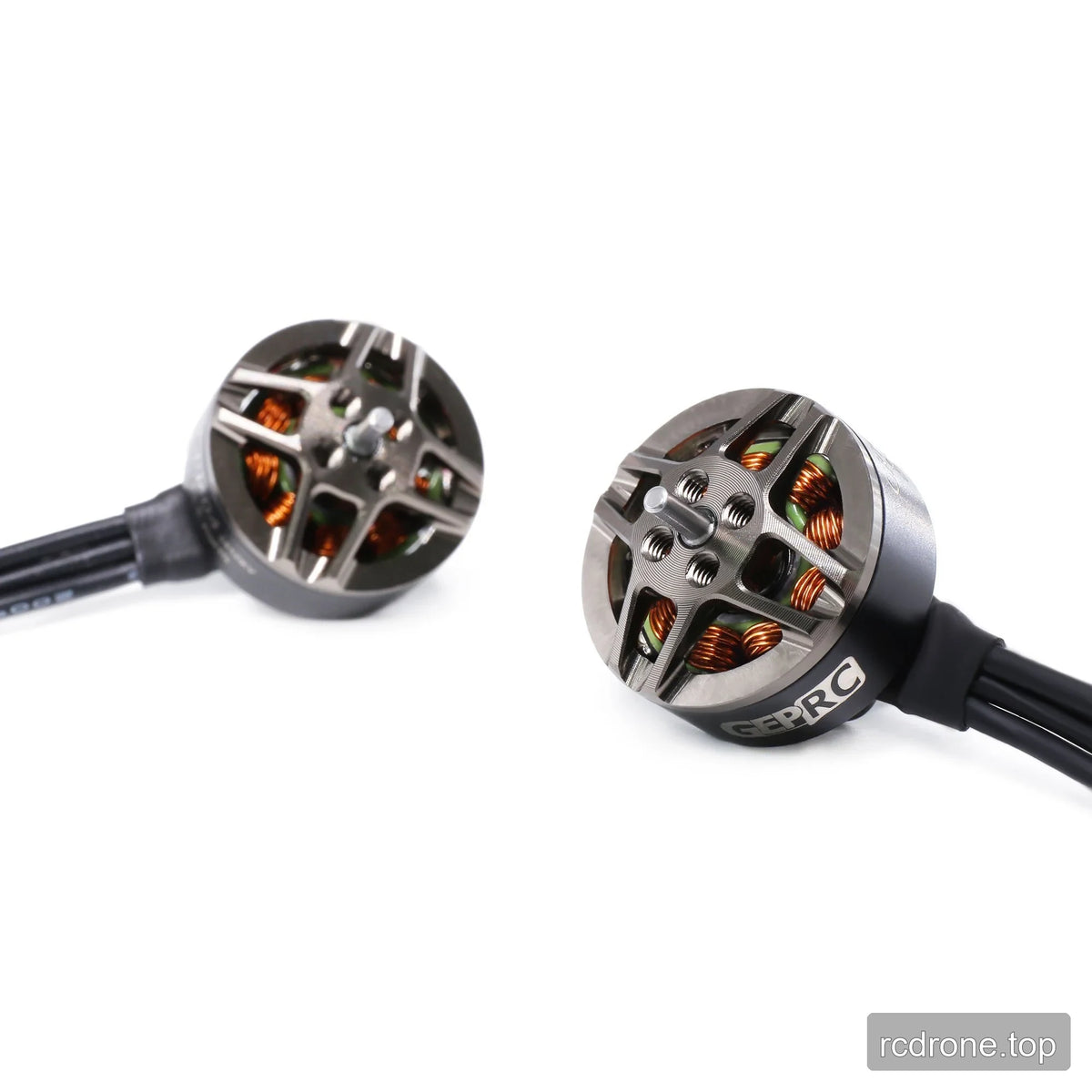 Pair of GEPRC GR1404 motors viewed from the top, showing shafts, threaded mounting holes, copper windings, and wires.