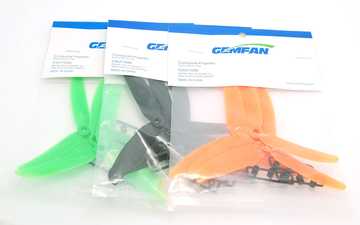 Gemfan propeller packs with blister bags showing green, black, and orange 3-blade props