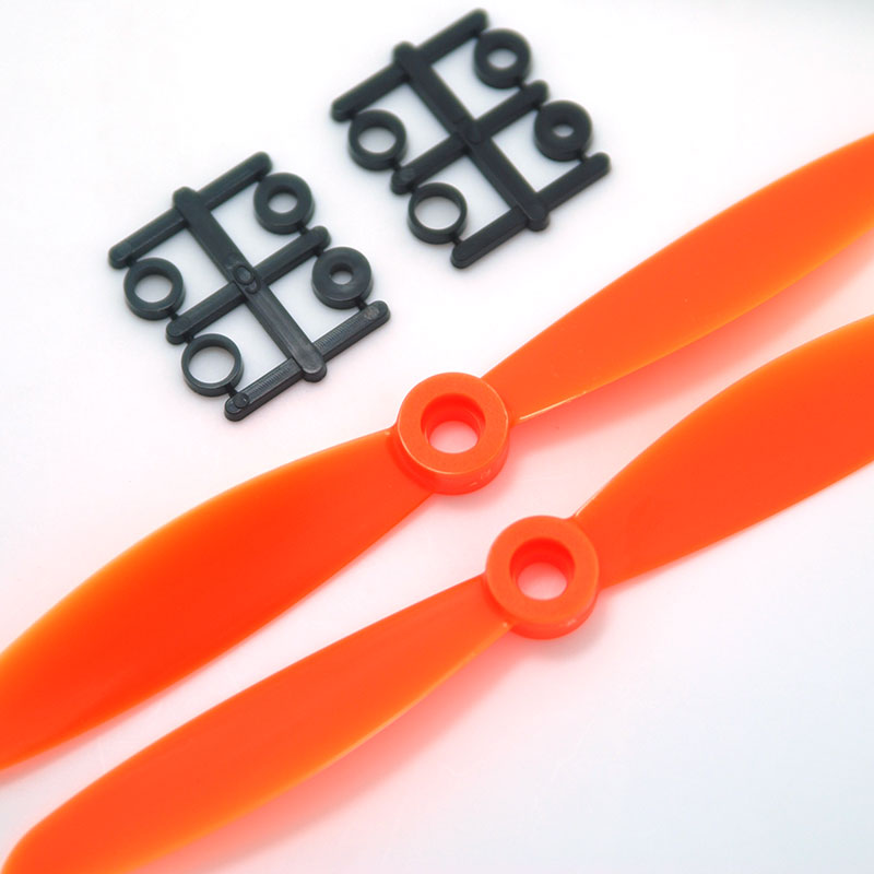 Orange 2-blade propellers with included mounting adapter rings on sprues, close-up hub detail