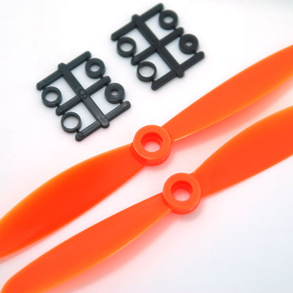 Orange 2-blade propellers with included mounting adapter rings on sprues, close-up hub detail