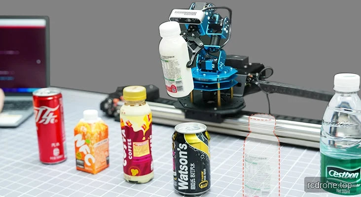 Robot arm gripping a beverage bottle beside assorted bottles and cans on a linear-rail workspace