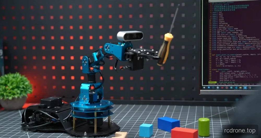 Robot arm gripping a screwdriver beside a programming monitor and colored geometric blocks