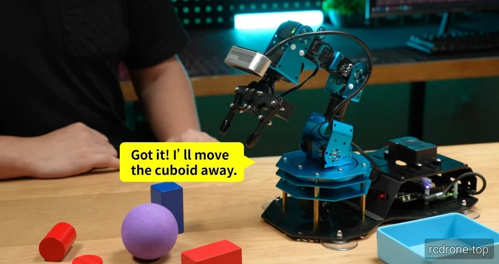 Robot arm beside a sphere, cylinders, cuboid blocks, and a tray during an object-moving demonstration