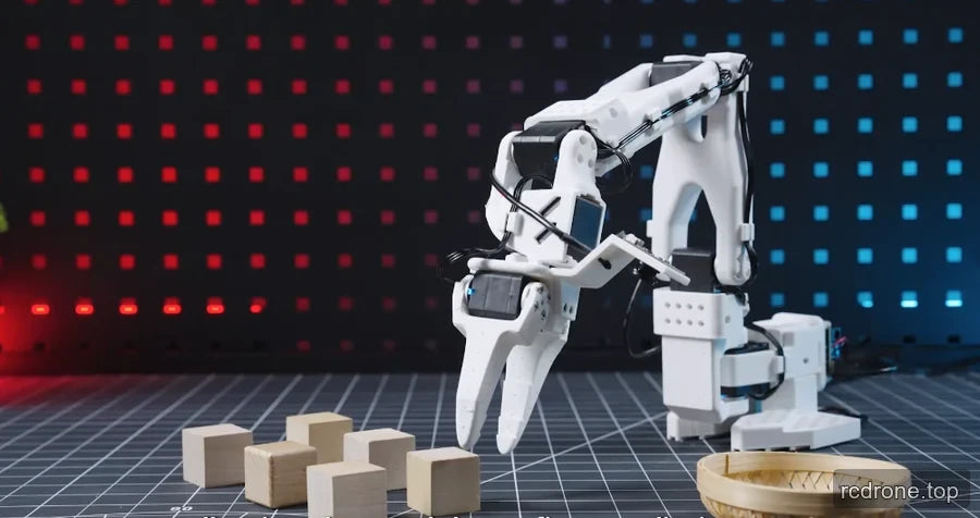 White robotic arm with open two-finger gripper above wooden blocks beside a basket