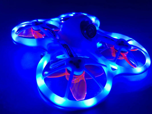 FPV drone with blue LED strip lighting installed around ducts, glowing in low light