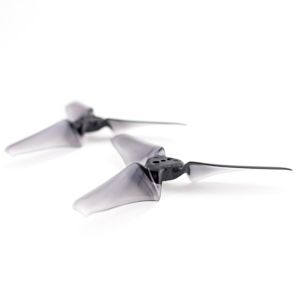 Translucent smoke-black tri-blade drone propellers angled view showing hub and blade profile