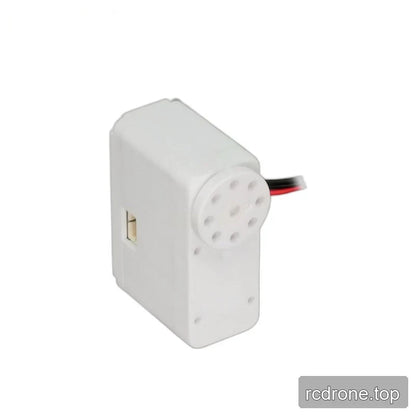 White servo from the opposite angle, with a left-side connector, perforated output disc and leads visible behind it.