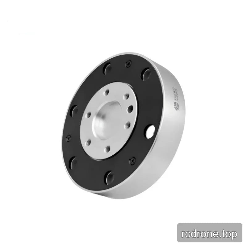 Tilted circular sensor showing its black mounting face, recessed silver center, and right sidewall with a small logo marking.