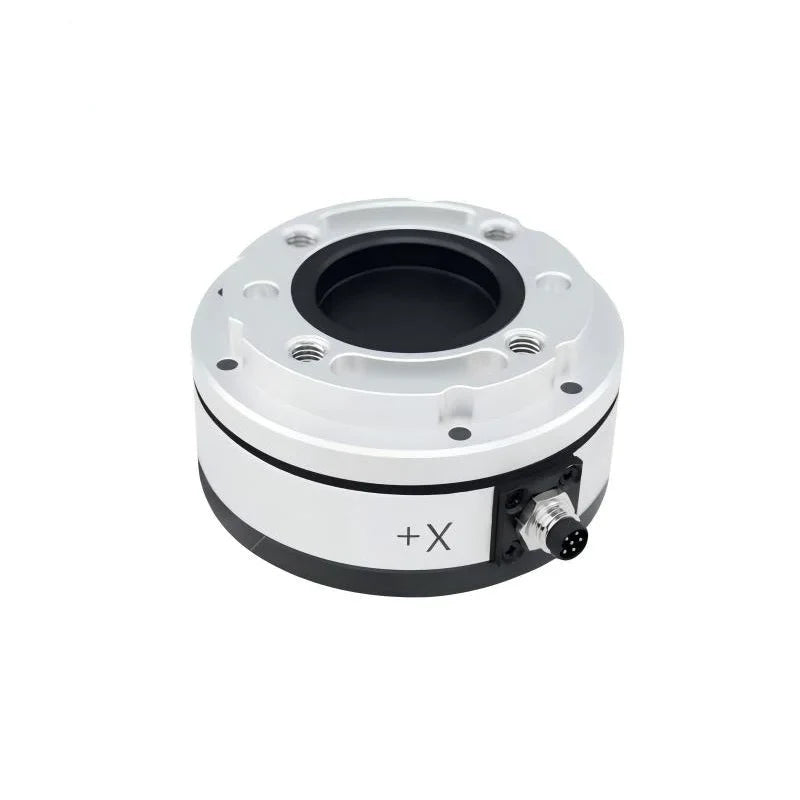 Silver circular sensor viewed from above, showing recessed center, threaded mounting holes, +X marking, and right-side connector.