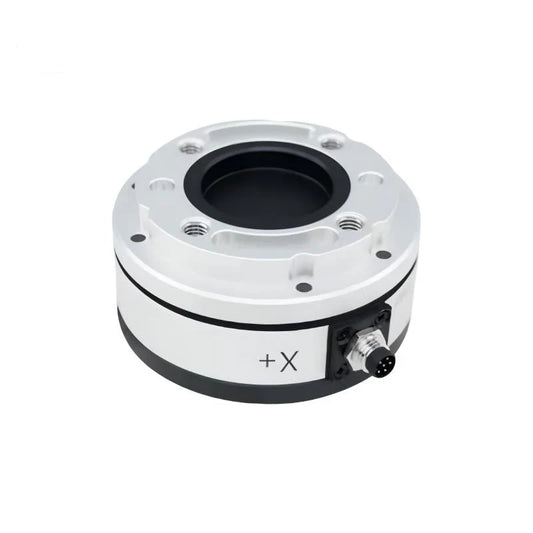 Silver circular sensor with recessed black center, threaded mounting holes, +X marking, and right-side connector.