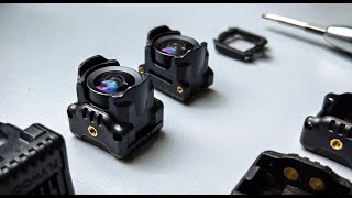 Flywoo O4 Wide Lens, Flywoo O4 wide-angle lens modules with mounting frame and small screws on a workbench