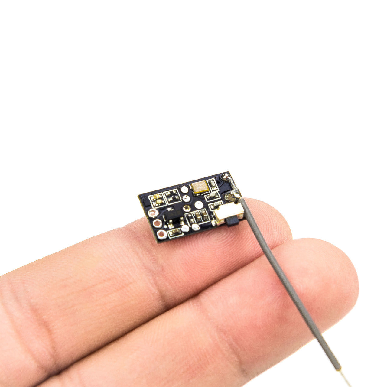 EMAX Tiny D8 Receiver shown on fingertip for size reference, top side components and antenna wire