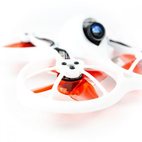 Translucent red 4-blade propeller installed in Tinyhawk-style ducted whoop frame close-up