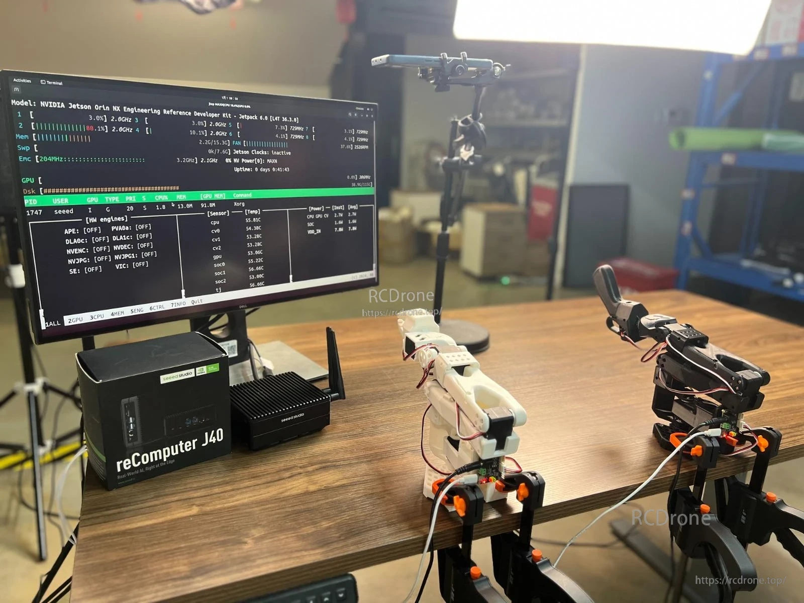 SO ARM 101 AI Arm, NVIDIA Jetson Orin NX Dev Kit with reComputer J40 shows AI arm components and real-time system monitoring data on screen.