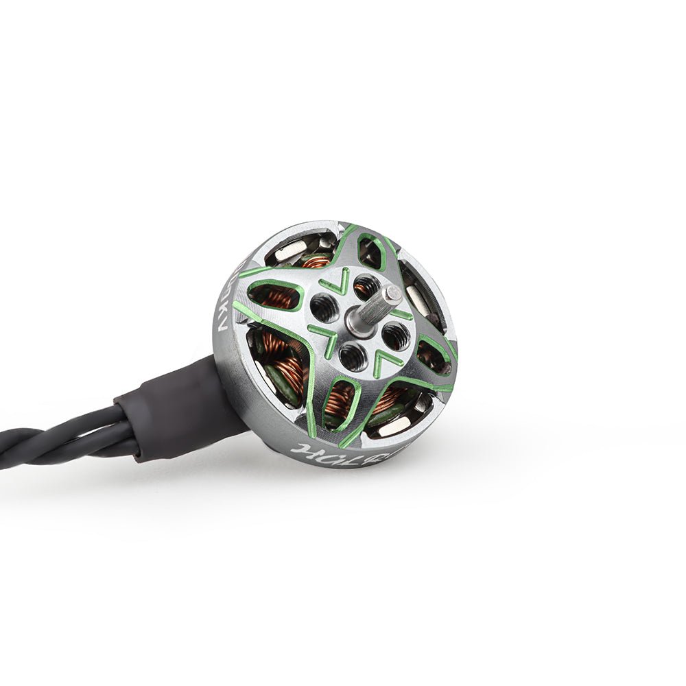 Top view of brushless motor showing green X-frame rotor cap, threaded mount holes, and wire lead