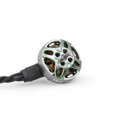 Top view of brushless motor showing green X-frame rotor cap, threaded mount holes, and wire lead